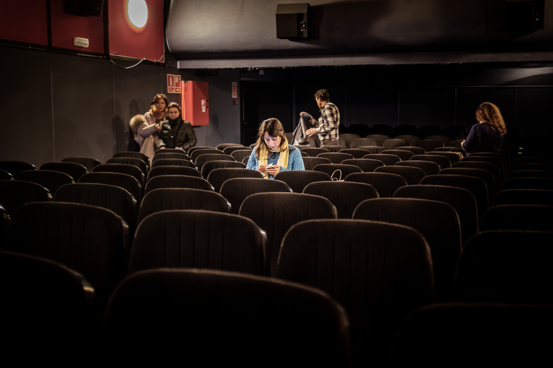 Una espectadora consulta el móvil entre sesiones en el Cine Mal